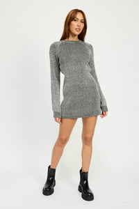 Woman wearing a gray knit dress with black boots on a white background