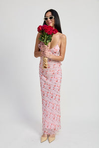Woman in a floral dress holding red roses against a white background