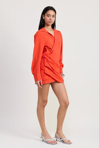 Woman wearing an orange dress against a plain background